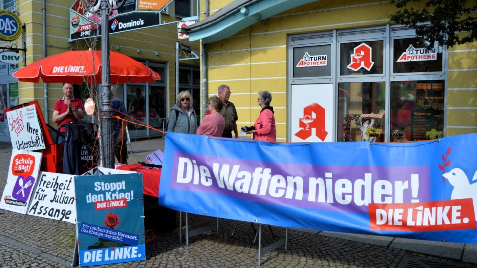 Infostand in Spremberg mit dem Banner:"Die Waffen nieder! - Die Linke"