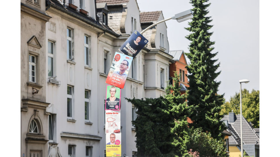 Straßenlaterne mit sehr vielen Wahlplakaten