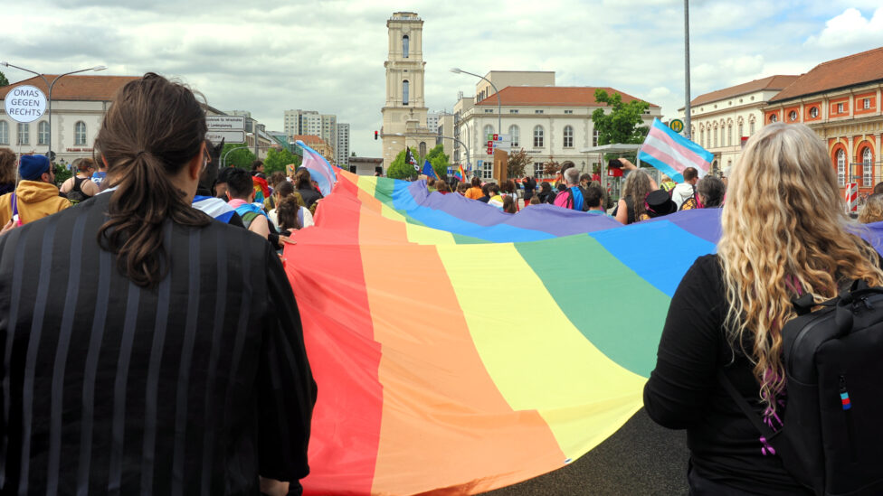 Demonstration mit sehr großer Regenbogenfahne